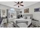 Cozy bedroom featuring a comfortable bed, ceiling fan, and bright natural light from the window at 1076 Firethorne Pass, Cumming, GA 30040