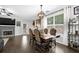 Elegant dining room features a stone fireplace, dark wood floors, and a stylish light fixture at 1076 Firethorne Pass, Cumming, GA 30040