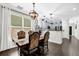 Dining area with a large window, modern light fixture, and open access to the kitchen at 1076 Firethorne Pass, Cumming, GA 30040