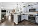 Open-concept kitchen with a bar, stainless steel appliances, and dark hardwood floors at 1076 Firethorne Pass, Cumming, GA 30040