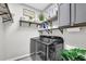 Modern laundry room with sleek washer and dryer, shelving, and ample storage at 1076 Firethorne Pass, Cumming, GA 30040