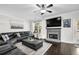 Inviting living room with fireplace, hardwood floors, and large leather sectional at 1076 Firethorne Pass, Cumming, GA 30040