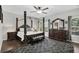 Main bedroom boasts a four-poster bed, sitting area, and hardwood floors at 1076 Firethorne Pass, Cumming, GA 30040