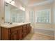 Bathroom featuring a double sink vanity, soaking tub with windows, and tiled floors at 2795 Autumn Dr, Canton, GA 30115