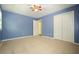 Bedroom featuring carpet, ceiling fan, blue walls and double door closet at 2795 Autumn Dr, Canton, GA 30115