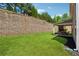 Lush backyard with a retaining wall and a covered patio, ideal for entertaining at 4050 Danbury Farms Dr, Cumming, GA 30040