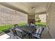 Covered patio featuring an outdoor dining set, ceiling fan, and a fireplace with a well-manicured lawn at 4050 Danbury Farms Dr, Cumming, GA 30040