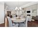 Open-concept dining area with hardwood floors, stylish chandelier, and view of the kitchen at 4050 Danbury Farms Dr, Cumming, GA 30040