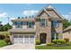 Charming two-story home featuring a brick facade, arched entryway, and a well-manicured lawn at 4050 Danbury Farms Dr, Cumming, GA 30040