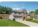 Two-story home featuring light gray siding, brick, shutters, and a two-car garage with a well-manicured lawn at 4050 Danbury Farms Dr, Cumming, GA 30040
