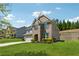 Two-story home showcasing brick and light gray siding, complemented by lush landscaping and a green lawn at 4050 Danbury Farms Dr, Cumming, GA 30040
