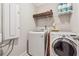 Functional laundry room equipped with modern washing machine, dryer, shelving, and ample storage space at 4050 Danbury Farms Dr, Cumming, GA 30040