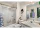 Neutral bathroom featuring shower with glass doors, a vanity, and a well-lit mirror, offering a clean and serene space at 806 Village Pl, Loganville, GA 30052
