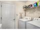 Functional laundry room equipped with a washer, dryer, storage shelves, and a door to outside making chores easy at 806 Village Pl, Loganville, GA 30052
