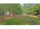 Spacious backyard view featuring a shed and partial view of the home surrounded by trees at 130 Laguna Springs Dr, Woodstock, GA 30188