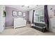 Cozy purple bedroom with a white crib, play area, and a bright window at 130 Laguna Springs Dr, Woodstock, GA 30188