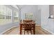 Bright dining room with hardwood floors and a wooden table with chairs, bathed in natural light from the windows at 130 Laguna Springs Dr, Woodstock, GA 30188