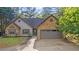 Charming home featuring a stone and gray siding exterior, complemented by a well-manicured front yard and a two car garage at 130 Laguna Springs Dr, Woodstock, GA 30188