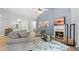 Cozy living room featuring a fireplace, vaulted ceilings, hardwood floors, a gray sofa, and a comfortable recliner at 130 Laguna Springs Dr, Woodstock, GA 30188