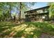 Spacious backyard featuring a covered patio, lush lawn, and mature trees, providing a perfect blend of comfort and nature at 247 Shallowford Nw Rd, Kennesaw, GA 30144