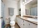Cozy bathroom with a granite countertop vanity, a decorative mirror, and a shower with a blue patterned curtain at 247 Shallowford Nw Rd, Kennesaw, GA 30144