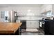 Well-lit kitchen with stainless steel appliances, white cabinets, a butcher block island, and subway tile backsplash at 247 Shallowford Nw Rd, Kennesaw, GA 30144