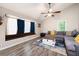 Inviting living room boasts a large window seat, wood floors and comfortable gray sectional at 247 Shallowford Nw Rd, Kennesaw, GA 30144