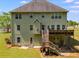 A two-story home with an outdoor deck and stairs leading to a grassy backyard at 4828 Planters Walk, Douglasville, GA 30135