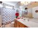 Bathroom features vanity, large mirror, and shower/tub combo with floral shower curtain at 4828 Planters Walk, Douglasville, GA 30135