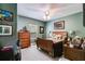 Comfortable bedroom is furnished with ceiling fan, wood furniture, and decorative artwork at 4828 Planters Walk, Douglasville, GA 30135