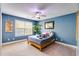 Blue bedroom with a window, ceiling fan, and a framed painting on the wall at 4828 Planters Walk, Douglasville, GA 30135