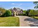 Beautiful two story brick home with red shutters and a long driveway approaching the attached two-car garage at 4828 Planters Walk, Douglasville, GA 30135