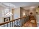 Bright hallway with a large window and decorative chandelier, with hardwood floors and detailed banister at 4828 Planters Walk, Douglasville, GA 30135