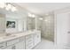 Bright bathroom features a double vanity, glass enclosed shower and soaking tub at 5817 Creek Indian Dr, Sugar Hill, GA 30518