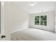 Cozy bedroom with a large window overlooking lush greenery at 5817 Creek Indian Dr, Sugar Hill, GA 30518