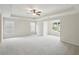Spacious bedroom featuring a tray ceiling with fan and plush neutral carpeting at 5817 Creek Indian Dr, Sugar Hill, GA 30518