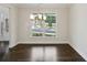 Bright dining room with hardwood floors, modern chandelier, and large window overlooking the neighborhood at 5817 Creek Indian Dr, Sugar Hill, GA 30518