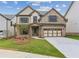 Beautiful new construction home featuring brick facade, neutral trim, tidy landscaping, and attached two car garage at 5817 Creek Indian Dr, Sugar Hill, GA 30518