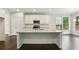 Clean kitchen with white cabinetry, granite countertops, stainless appliances, and dark hardwood floors at 5817 Creek Indian Dr, Sugar Hill, GA 30518