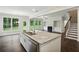 Open-concept kitchen with granite island, stainless appliances, and a view into the living room at 5817 Creek Indian Dr, Sugar Hill, GA 30518