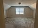 Spacious carpeted bedroom with dormer ceiling and ample natural light from the window at 893 Port West Dr, Auburn, GA 30011
