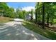 Two story home with a gray exterior, outdoor deck, and a long driveway surrounded by mature trees at 15 Swallow Se Dr, White, GA 30184