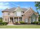 Charming two-story home with a manicured lawn, stone accents, and inviting front porch at 3820 Preserve Crossing Ln, Cumming, GA 30040