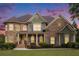 Two-story home with stone and siding accents against a vivid sunset sky at 3820 Preserve Crossing Ln, Cumming, GA 30040