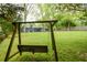 Wood swing in a large backyard with well-manicured lawn, beautiful trees, and view of the home at 126 N Barton St, Norcross, GA 30071