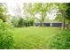 Large backyard with beautiful lush grass, mature trees, and a view of the home at 126 N Barton St, Norcross, GA 30071