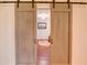 Interior view of light colored wooden barn door opening into sitting area at 126 N Barton St, Norcross, GA 30071