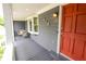 Charming covered porch with seating area and view of the front yard with red front door at 126 N Barton St, Norcross, GA 30071