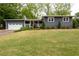 Charming home boasts a manicured lawn, complemented by a one-car garage and covered front porch at 126 N Barton St, Norcross, GA 30071