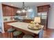 Modern kitchen featuring an island with bar seating, stainless steel appliances, and cherry cabinets at 126 N Barton St, Norcross, GA 30071